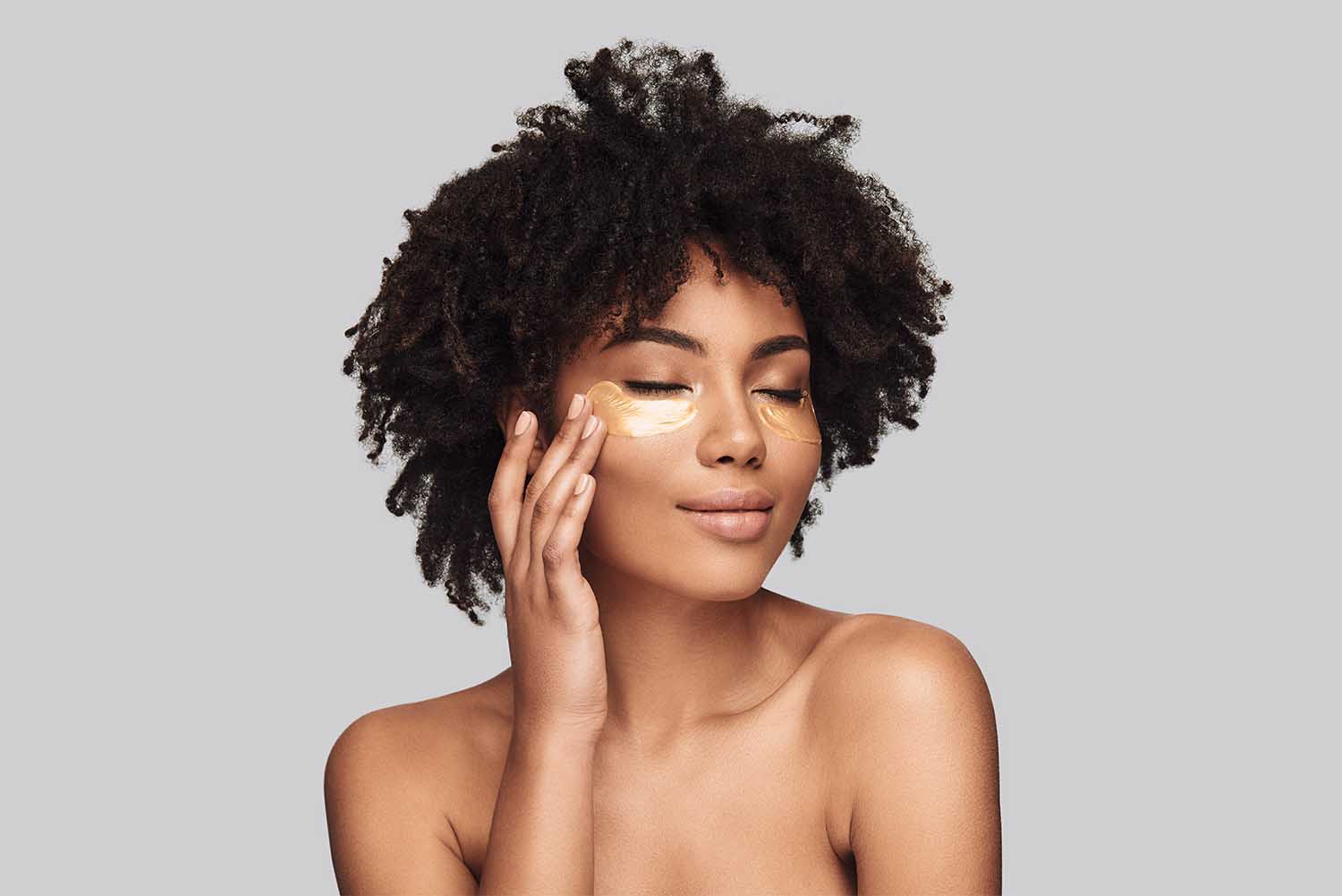 Need some collagen. Attractive young African woman applying medi